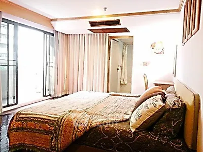 Spacious bedroom with large windows and elegant decor in a modern apartment.