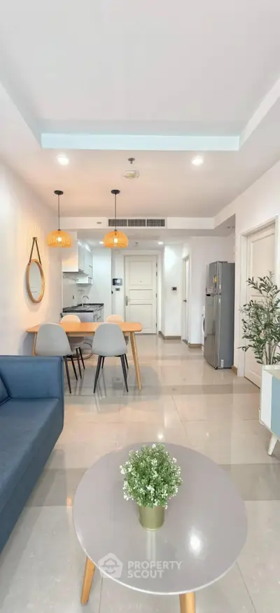 Modern open-plan living room with dining area and sleek kitchen in a stylish apartment.