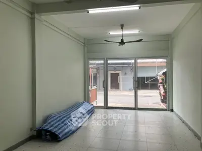 Spacious empty room with large windows and ceiling fan, ideal for customization.