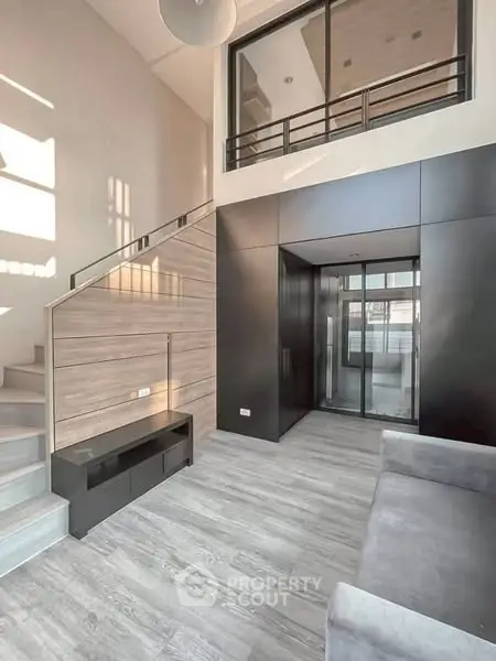 Modern living room with high ceiling and stylish staircase