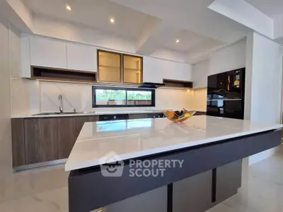 Modern kitchen with sleek design, featuring a large island and built-in appliances, perfect for culinary enthusiasts.