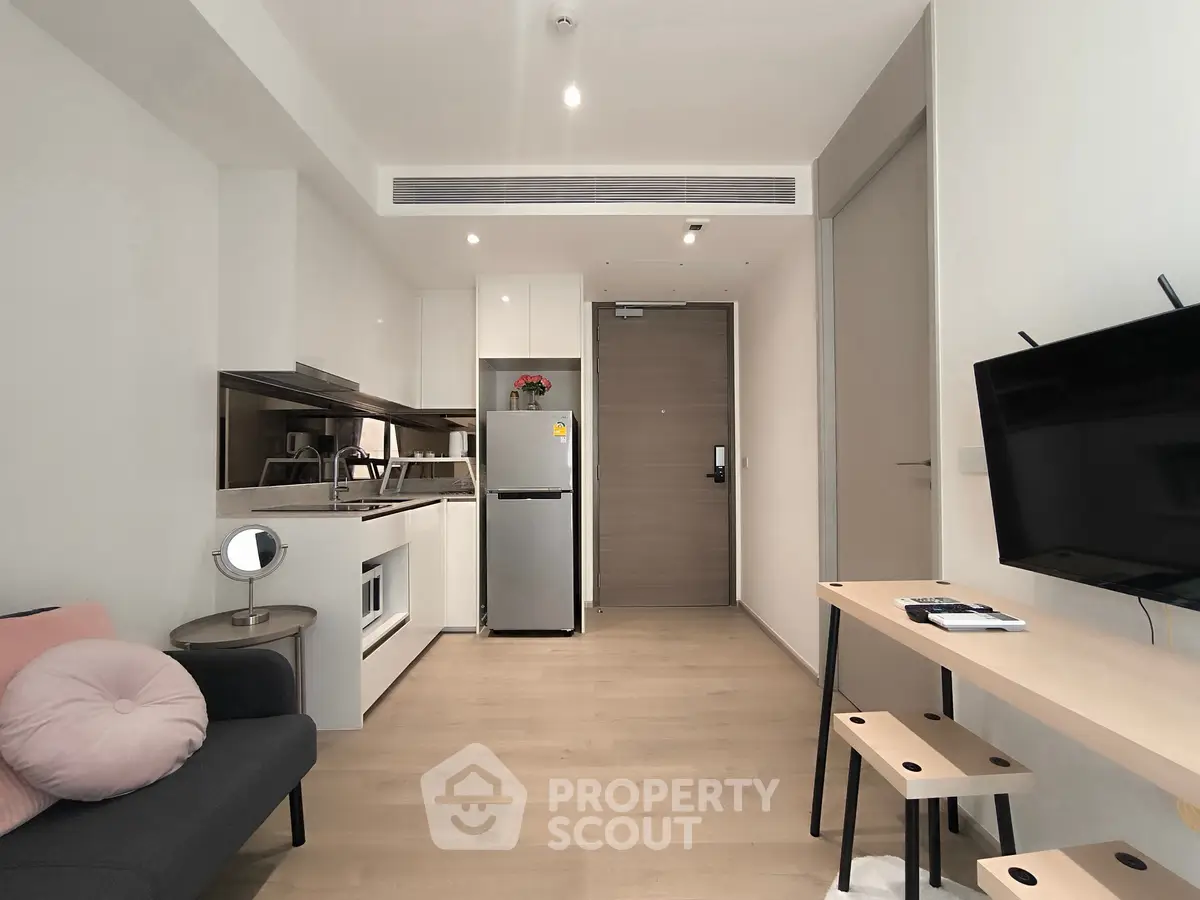 Modern apartment interior with sleek kitchen and cozy living area, featuring minimalist design and neutral tones.