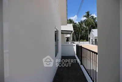 Modern white exterior with tropical surroundings and sleek railing design