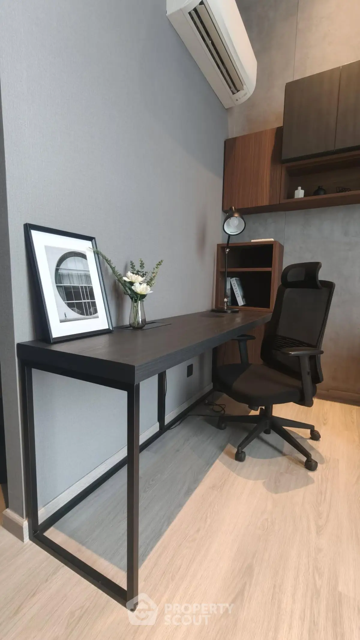 Modern home office with sleek desk, ergonomic chair, and stylish decor in a contemporary apartment.