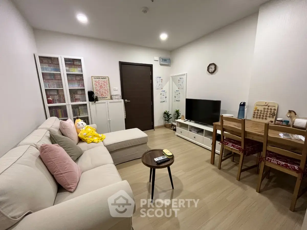 Cozy living room with modern decor, featuring a comfortable sofa, TV unit, and dining area, perfect for relaxation.