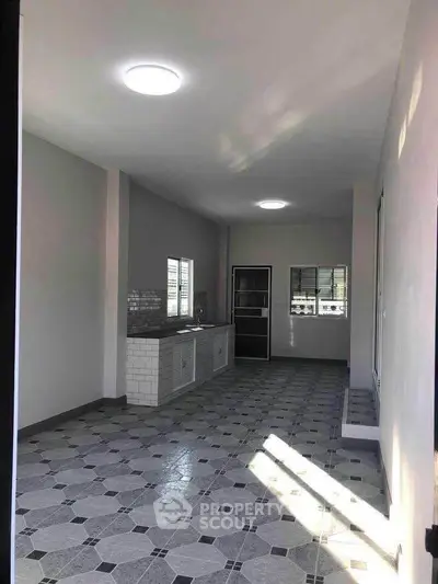 Spacious kitchen with modern tile flooring and ample natural light.