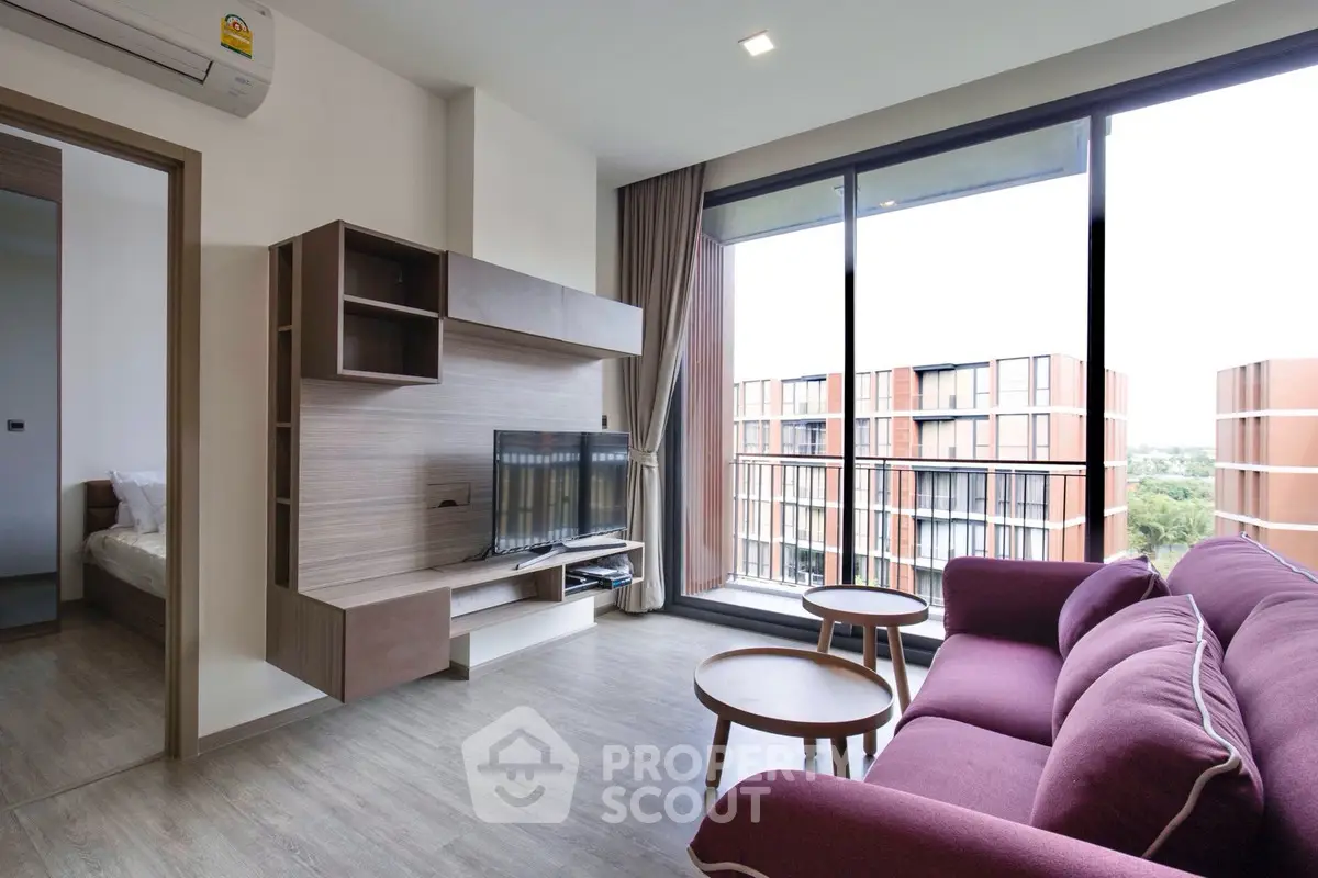 Modern living room with large windows and stylish furniture in a high-rise apartment.