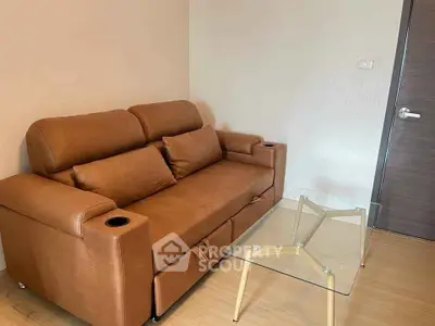 Cozy living room with modern brown leather sofa and glass coffee table