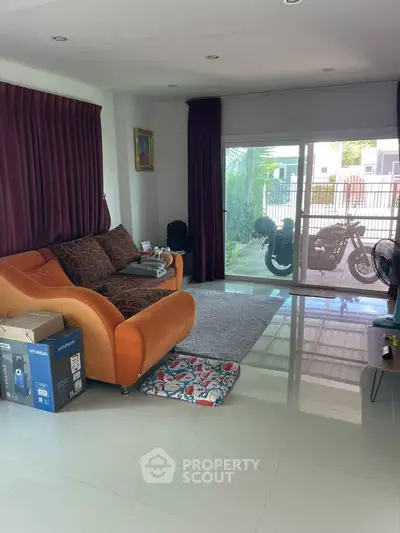 Spacious living room with modern decor and sliding glass doors leading to outdoor area.