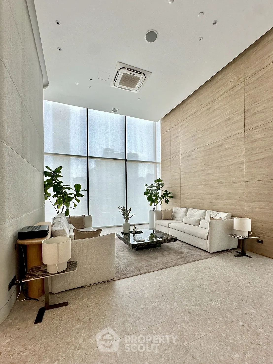 Luxurious modern living room with high ceilings and large windows, featuring elegant furniture and indoor plants.