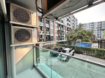 Modern apartment balcony with pool and parking view in urban setting