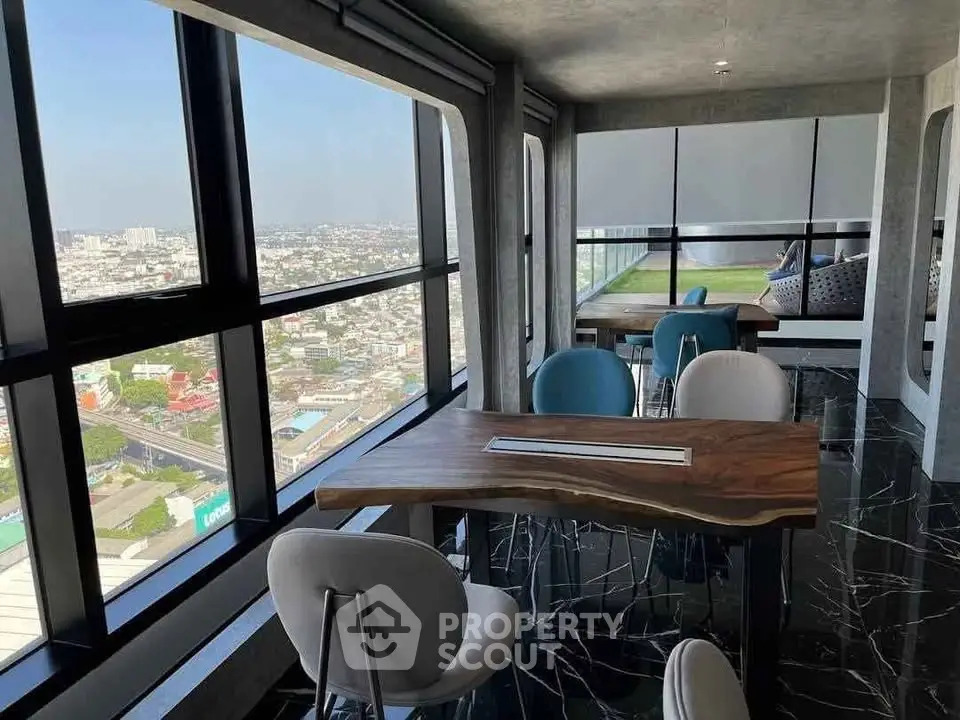 Stunning high-rise view from modern lounge with sleek furniture and panoramic windows.