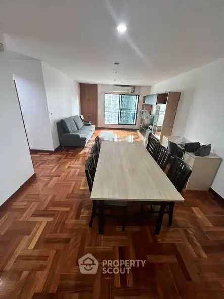 Spacious living room with elegant wooden flooring and modern furniture in a stylish apartment.