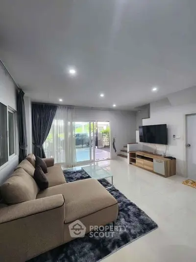 Spacious modern living room with large sofa and entertainment center
