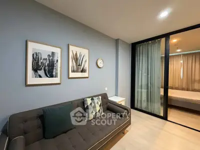 Modern living room with stylish decor and sliding glass doors leading to a cozy bedroom.