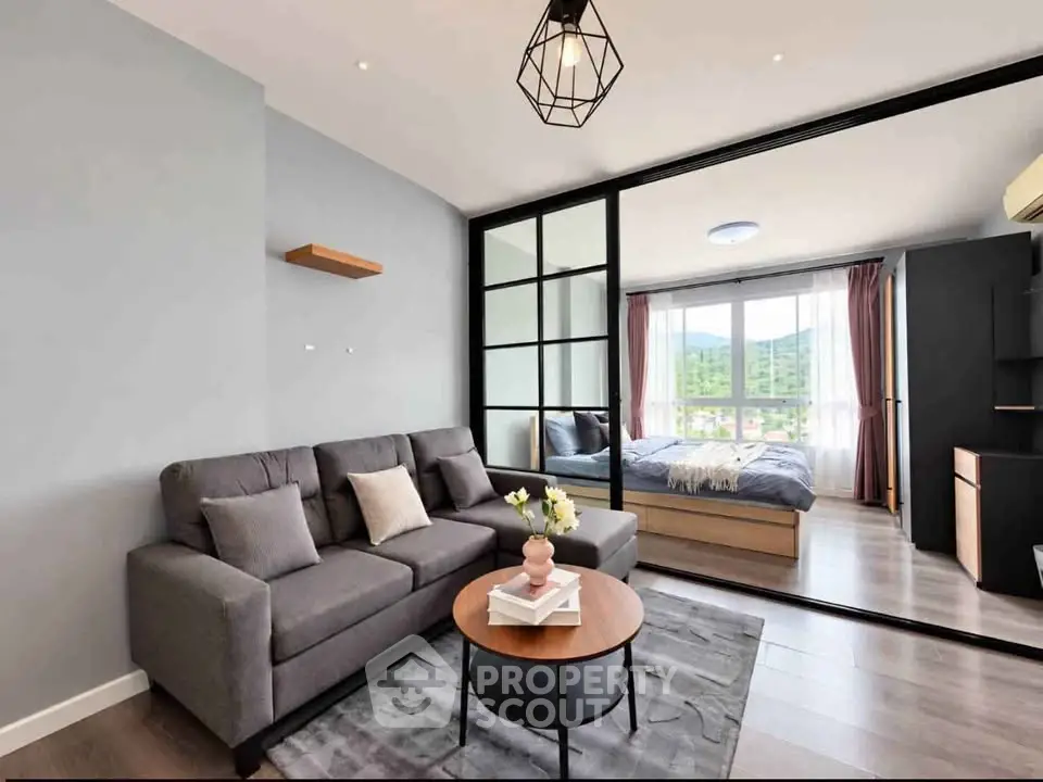 Modern living room with stylish decor and view into a cozy bedroom