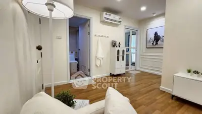 Chic apartment interior with modern decor and wooden flooring, featuring a cozy living area and stylish bathroom access.