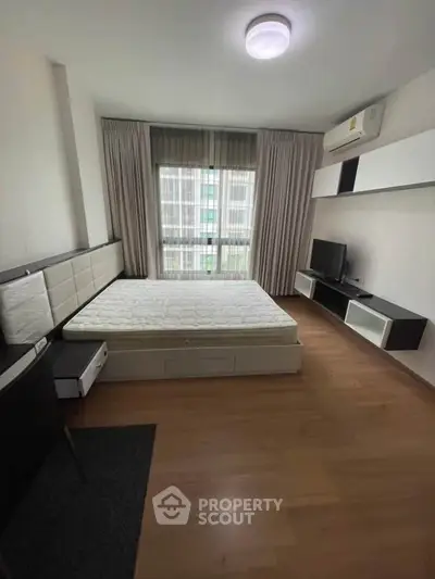Modern bedroom with sleek design, featuring a comfortable bed, stylish TV unit, and ample natural light.