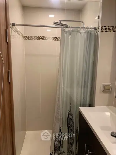 Modern bathroom with sleek shower and elegant vanity in contemporary apartment.