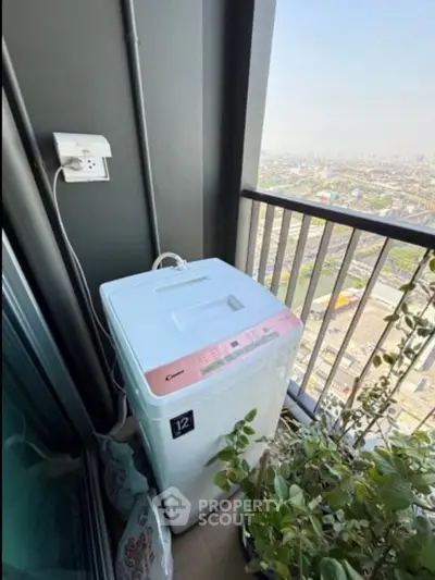 High-rise balcony with washing machine and city view, perfect for urban living convenience.