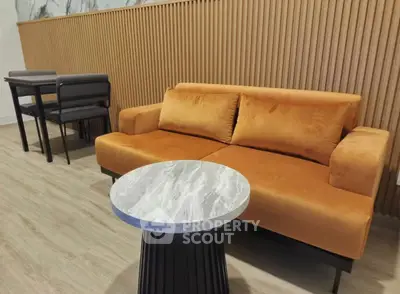 Modern living room with stylish orange sofa and elegant marble coffee table