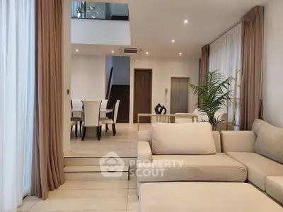 Spacious modern living room with elegant dining area and neutral decor, perfect for family gatherings.