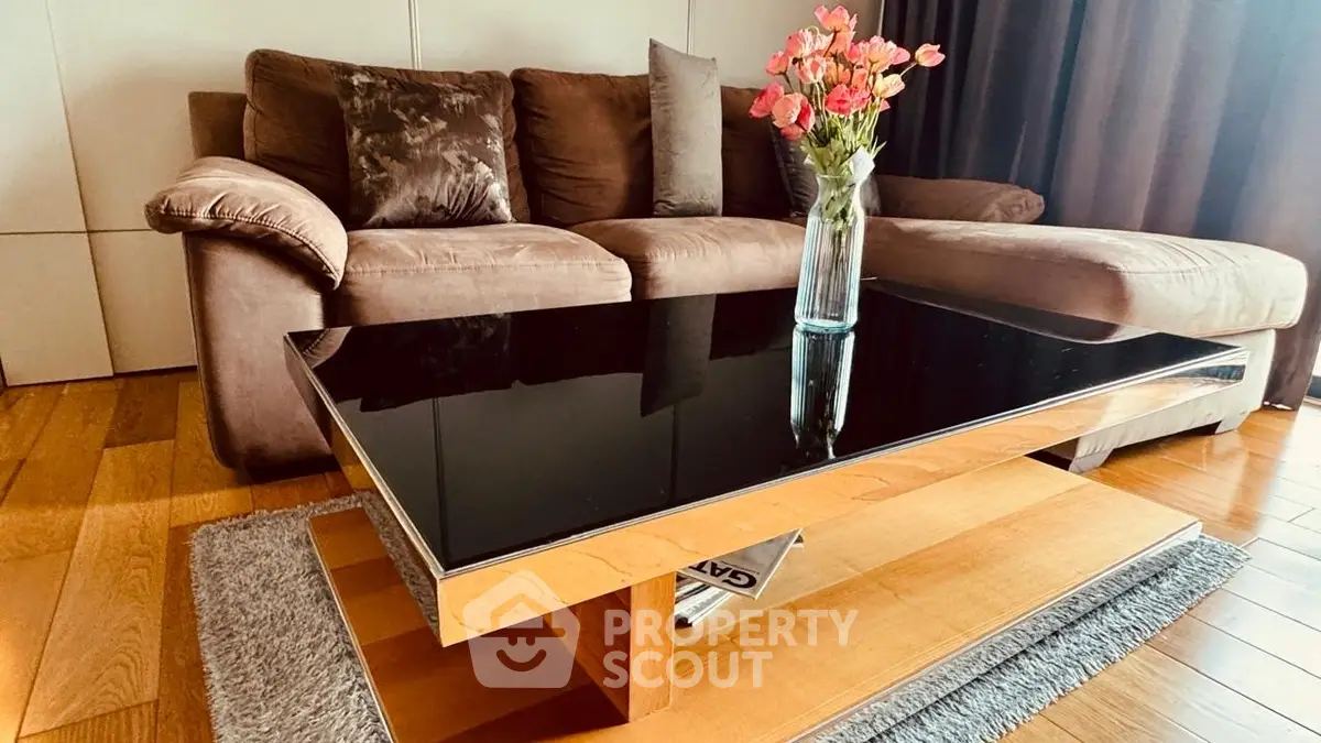 Stylish living room with modern sofa and sleek glass coffee table.