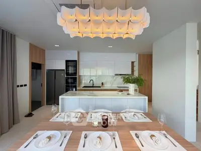 Modern kitchen with elegant dining setup and stylish lighting fixture