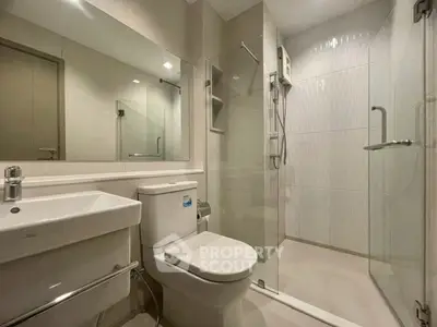 Modern bathroom with glass shower and sleek fixtures in a contemporary apartment.