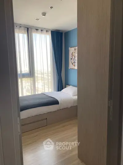 Cozy bedroom with large windows and modern decor in a stylish apartment.