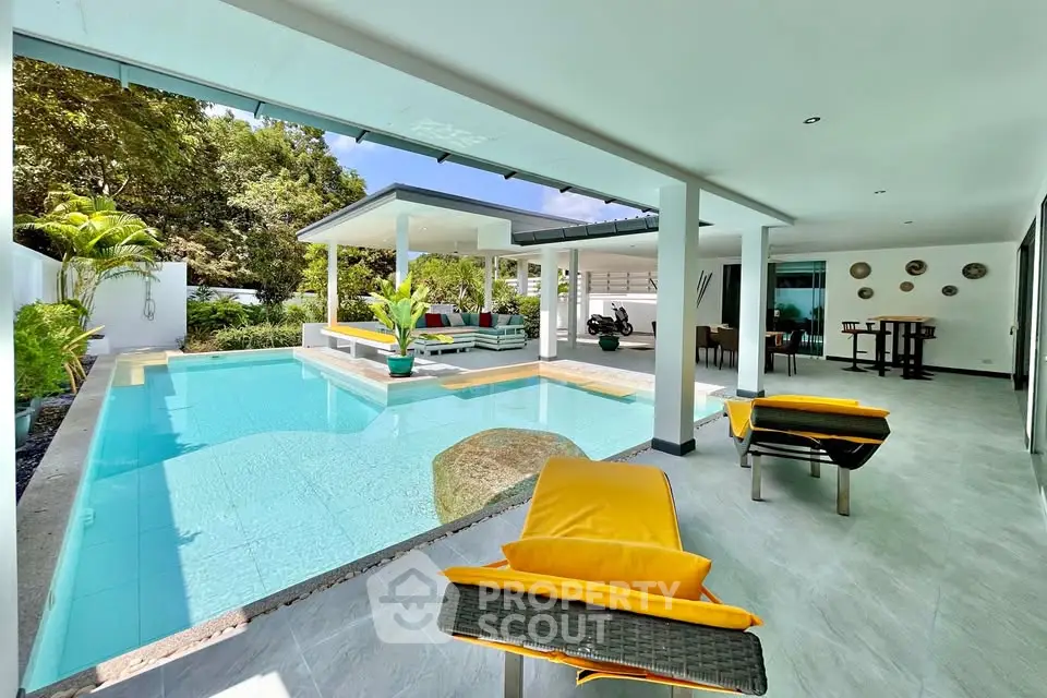 Luxurious poolside patio with modern design and vibrant seating in tropical setting.