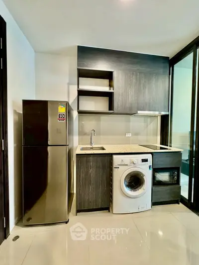 Modern kitchen with sleek appliances and stylish cabinetry in a contemporary apartment.
