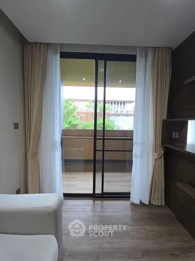 Modern living room with sliding glass doors leading to a spacious balcony.