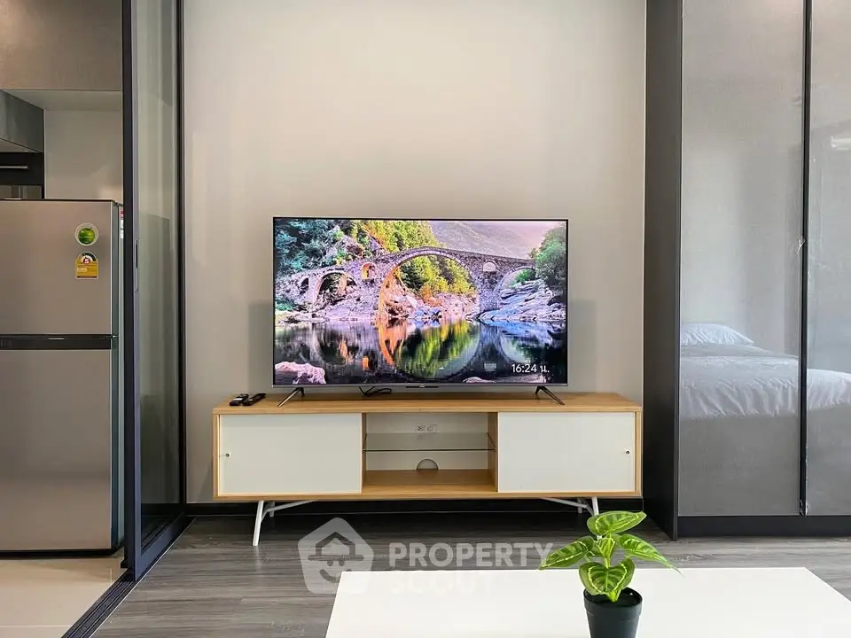 Modern living room with sleek TV setup and stylish decor in a contemporary apartment.