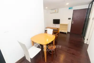 Cozy living room with wooden flooring and modern furniture, perfect for small gatherings.