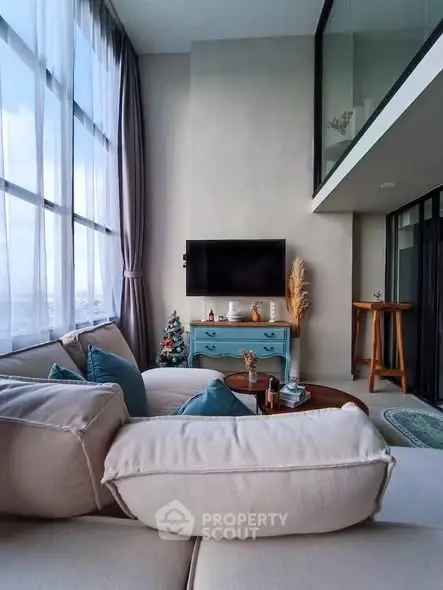 Modern living room with high ceilings, large windows, and stylish decor in a luxury apartment.