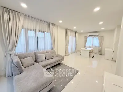 Spacious modern living room with elegant gray sofa and bright natural light