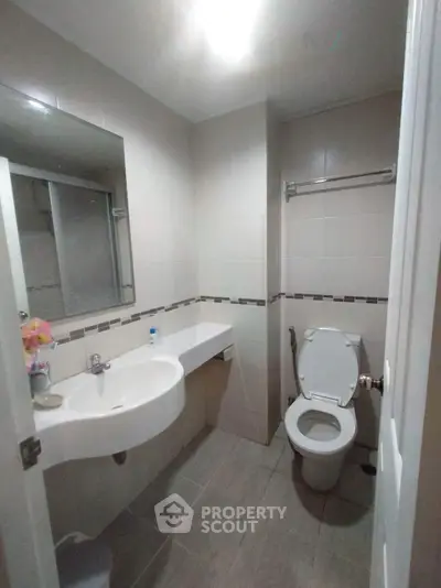 Modern bathroom with sleek fixtures and neutral tiles, perfect for a contemporary home.