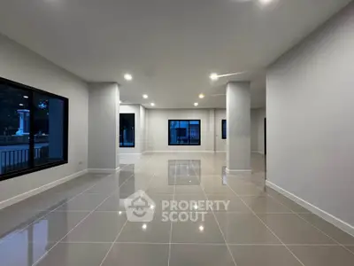 Spacious modern living room with glossy tiled floors and large windows.