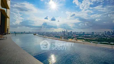 Stunning rooftop infinity pool with panoramic city skyline view under a bright blue sky.