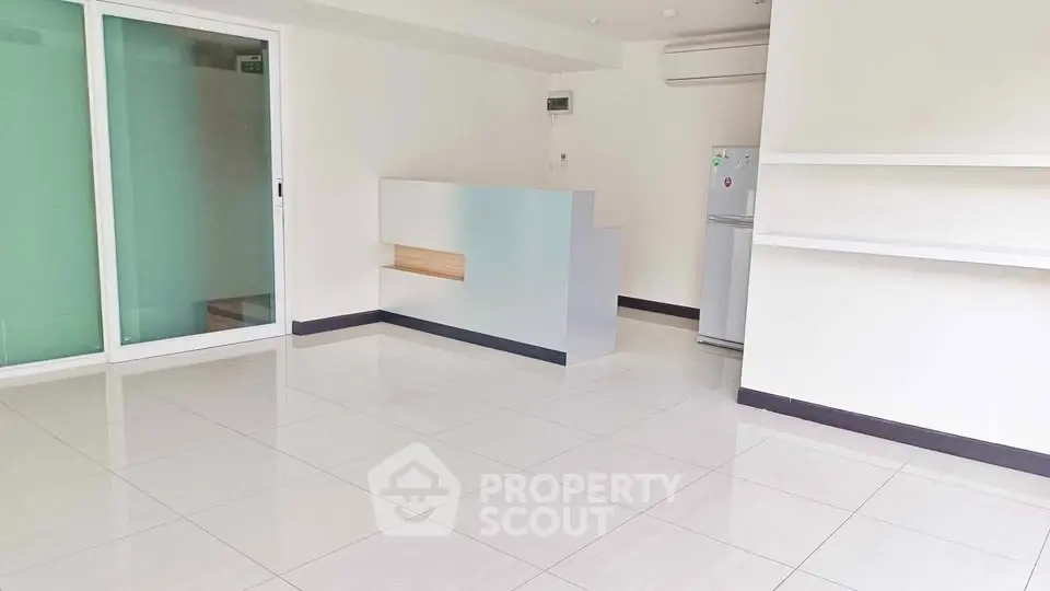 Spacious modern living room with sleek tile flooring and minimalist design.