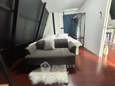Cozy attic bedroom with modern decor and plush seating area, perfect for relaxation.