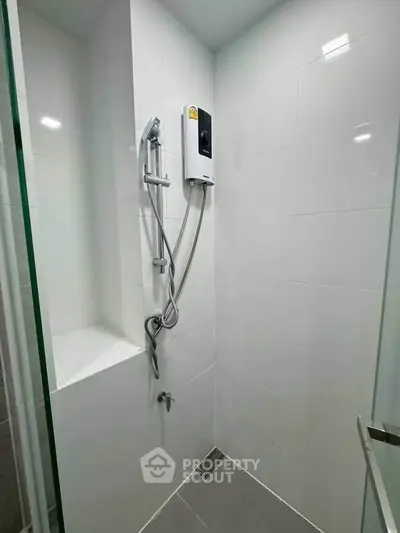 Modern bathroom with sleek shower and white tiled walls, perfect for a contemporary home.