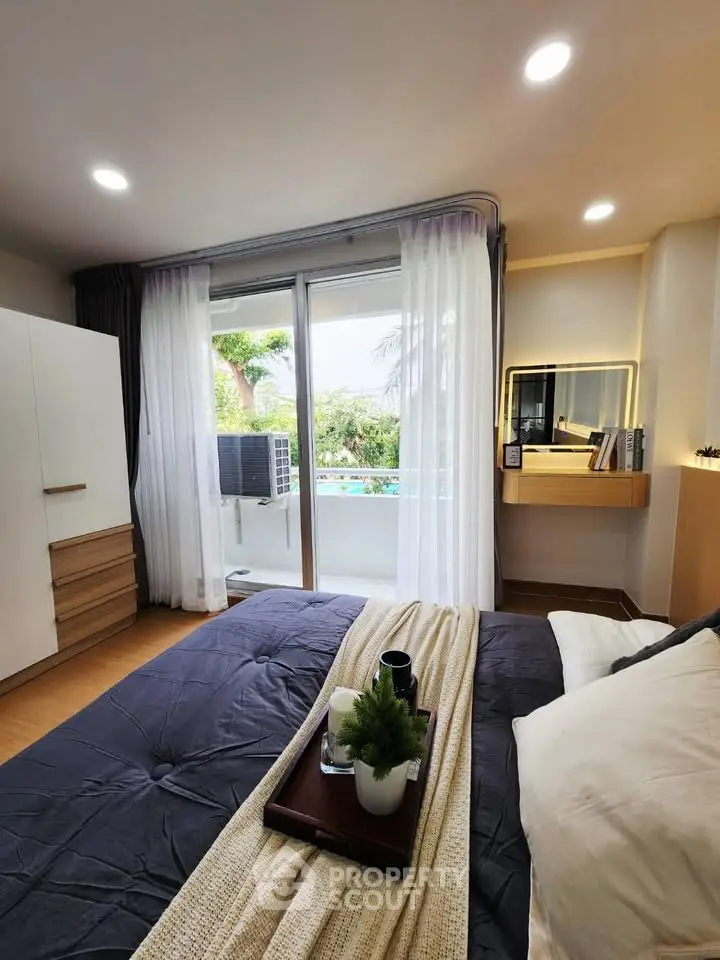 Cozy bedroom with balcony access and modern decor, featuring a comfortable bed and natural light.
