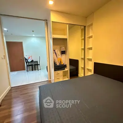 Spacious bedroom with wooden flooring and built-in wardrobe in modern apartment
