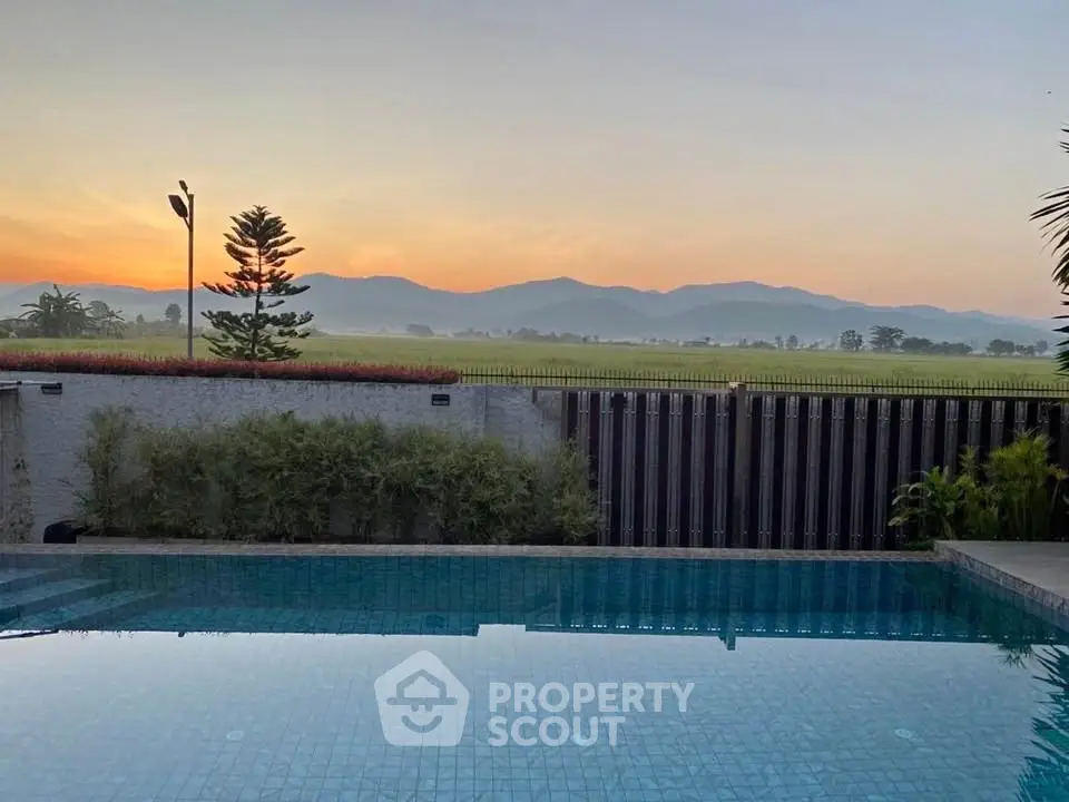 Stunning poolside view with serene mountain backdrop at sunrise, perfect for luxury living.