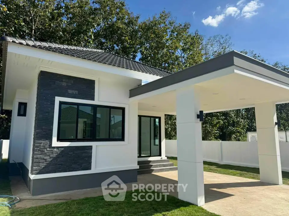Modern single-story house with sleek design and spacious carport in a serene neighborhood.