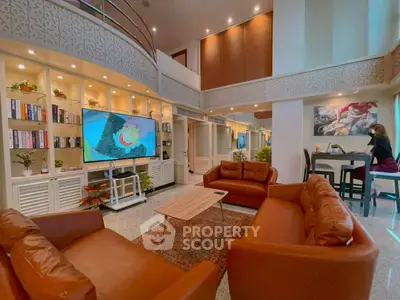 Luxurious living room with high ceilings, elegant decor, and cozy leather sofas in a modern apartment.