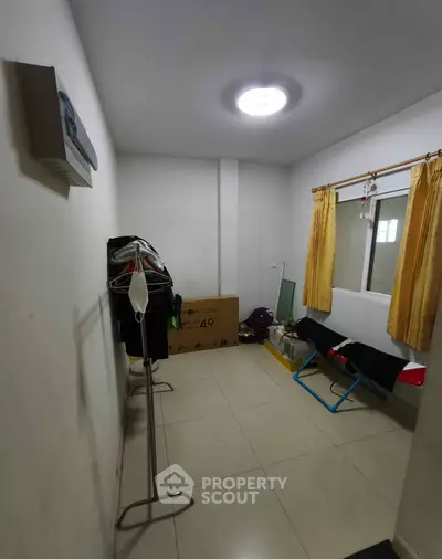 Compact storage room with natural light and tiled flooring, ideal for organizing essentials.