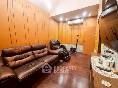 Luxurious living room with leather sofa and massage chair, featuring elegant wood paneling and modern air conditioning.